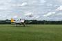 Au point d'attente de la piste 28 de l'aérodrome de La Ferté-Alais, un pilote d'un Nynja (ULM) attend qu'un North American T28 atterrit.